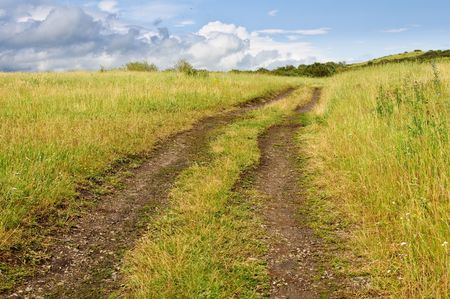 Field road near lake after a rain and the bright skyの写真素材