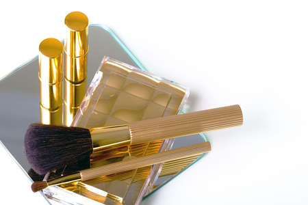 Makeup accessories in gold on the mirror backgroundの写真素材