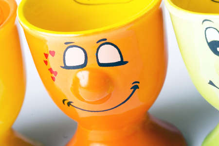 Orange ceramic egg holder with cute face expressionの写真素材