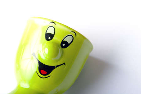 Bright green ceramic egg holder with smiley face expressionの写真素材