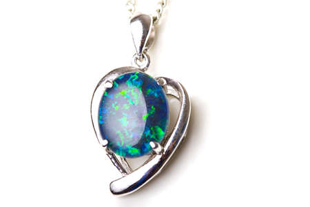 Elegant beautiful jewelry single opal stone pendant in sterling silver heart shape setting isolated の写真素材