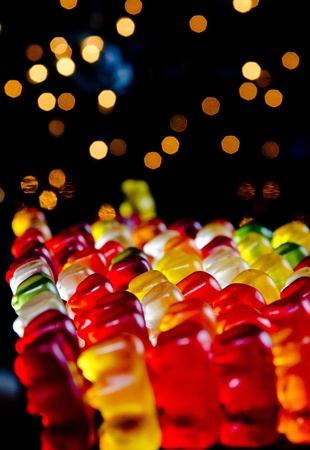 Army of sweet colorful jelly teddies with blinking lights on black backgroundの写真素材