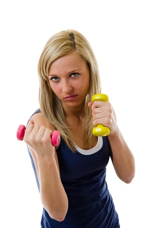 Angry looking girl training with dumbbellsの写真素材
