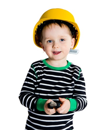 Happy smiling 2-3 years old boy in yellow helmet playing with pliers - isolated on white backgroundの写真素材