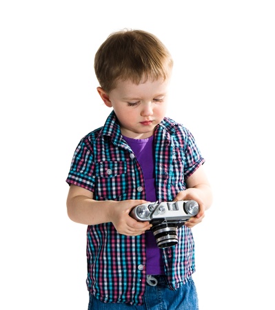 Boy playing with photo camera -  isolated on white backgroundの写真素材