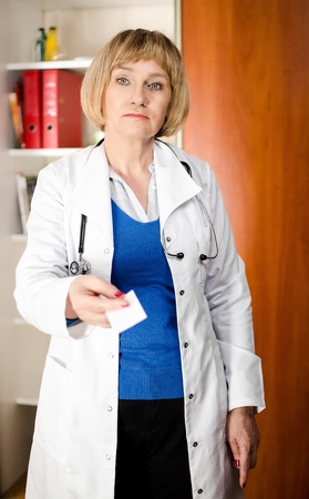 Mature doctor woman giving business cardの写真素材
