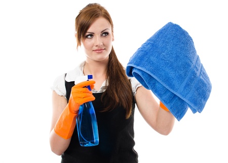 Pretty young woman in orange protective gloves cleaning window with spray and towelの写真素材