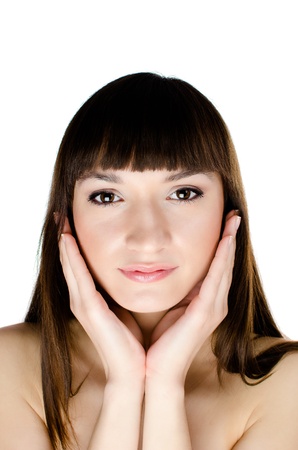 Beautiful dark-haired woman touching her face with both handsの写真素材