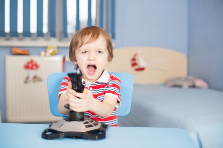 Baby boy screaming when playing computer games with joystick