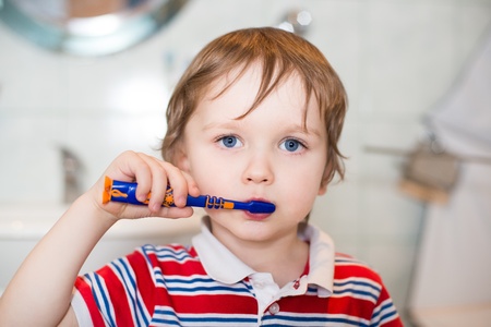 Little child boy brushing his teeth in bathroomの写真素材