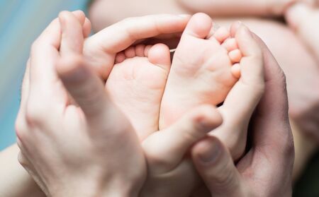 Parents  holding with love little newborns feetsの写真素材