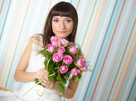 Beautiful bride holding a bouquet of pink rosesの写真素材