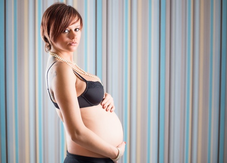 Standing pregnant woman in underwearの写真素材