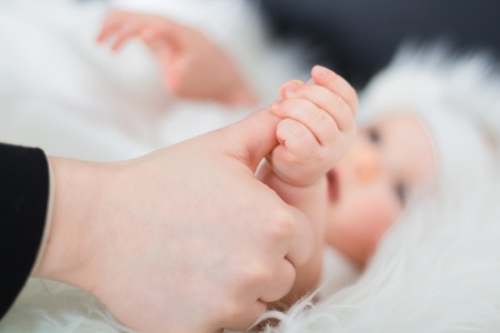 Mother gently holding her baby little handの写真素材