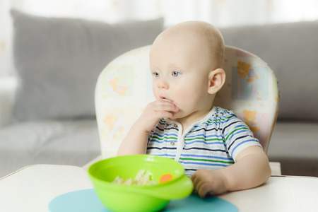 6 months little boy is eating pasta for dinnerの写真素材