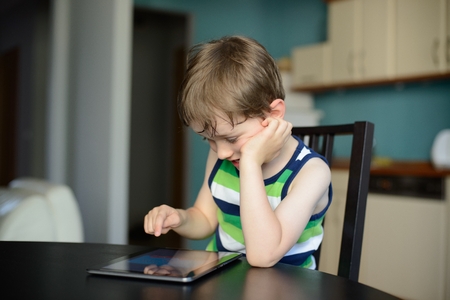 preschooler play games on the tablet at homeの写真素材