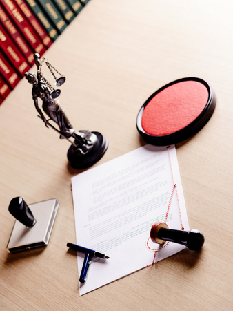 Notary public working tools, his stamp, pen, figurine of goddess of justice Themis and contract waiting for his signの写真素材