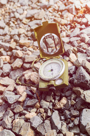 Compass on gravel mountain hiking trail. Winter mountain trip concept