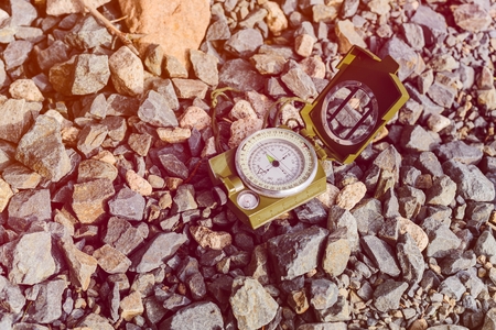 Compass instrument on gravel mountain hiking trail. Winter mountain trip conceptの写真素材