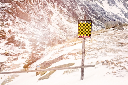 Avalanche sign in winter mountains with snow. Polish inscription Avalanche Danger - Trail Closedの写真素材