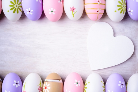 Easter eggs and wooden heart  on a grey wooden background. White wooden heart for room or space for copy, text, words,  your message. Easter conceptの写真素材