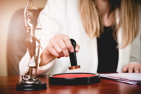 Woman Notary Public stamping the Power of attorney. Law office.の写真素材