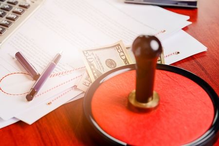 Money under the notary public stamper. Bribe, corruption concept.の写真素材