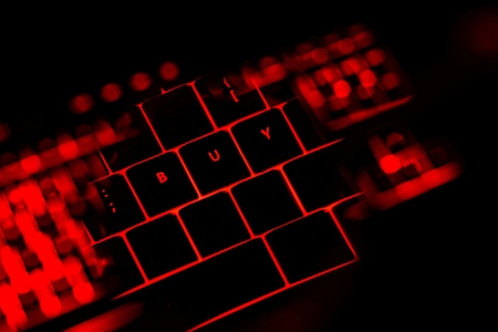 Buy text on the illuminated buttons of the keyboard by night. Internet shopping concept.の写真素材