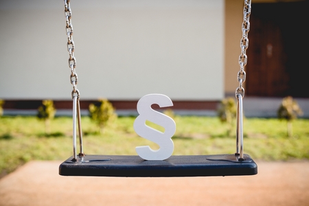 White paragraph symbol on children chain swing. Family law or playground accident concept.の写真素材