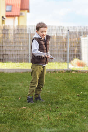 Kid helping in the garden. Rakes the grass. Spring gardeningの写真素材