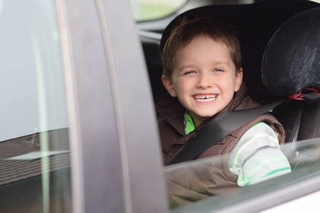 Happy little boy in car safety seat. Looking through the window Children car safety conceptの写真素材