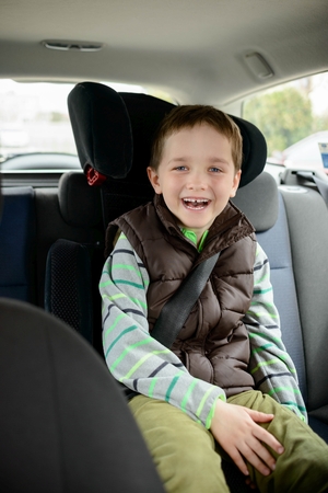 Smiling little boy in car safety seat. Children car safety conceptの写真素材