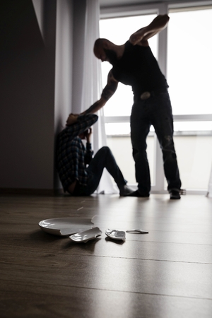 Muscular bearded man beating his redhead wife. Domestic violence and abuseの写真素材