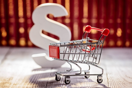 Little trolley - pushcart with the symbols of law in court library with legal codes. Commercial law conceptの写真素材