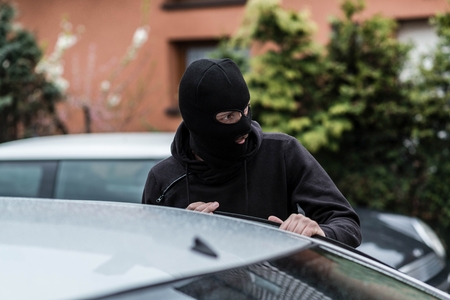 Man dressed in black with a balaclava on his head entering the vehicle and stealing a car. Car...