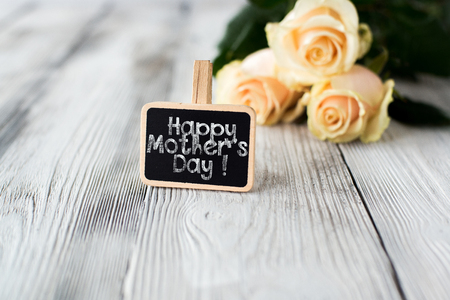 Roses and small blackboard with " Happy Mother's Day" inscription on old grey floor.の写真素材