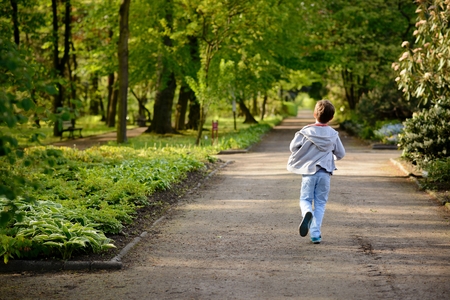 Children's Day.  Little boy running in the park. Back viewの写真素材