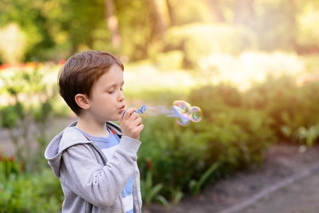 Children's Day.  Little boy blowing soap bubbles in the parkの写真素材