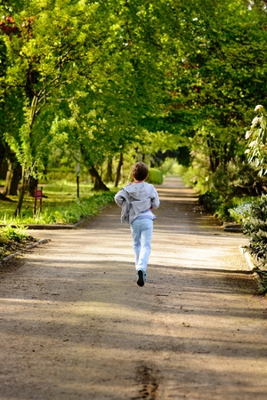 Children's Day.  Little boy running in the park. Back viewの写真素材