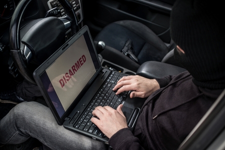 Car Thief tries to disarm car security systems and immobiliser with laptop computer. Car thief, car theftの写真素材