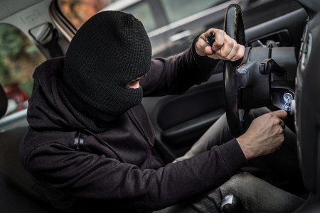 Car Thief tries to start the car with a screwdriver in the ignition. Car thief, car theftの写真素材