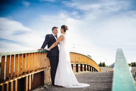 Wedding session in park. Happy newlyweds on the bridge in parkの写真素材
