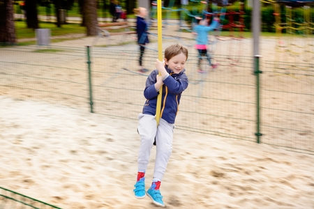 The boy is sliding down a rope on the playgroundの写真素材