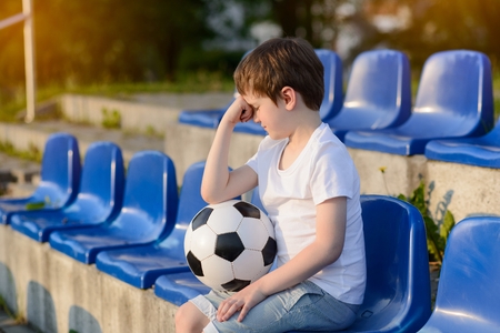 Small football fans disappointed after the loss goal by his favorite teamの写真素材