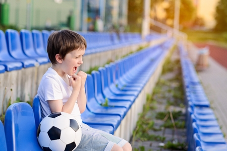 Little football fan happy after a goal for his favorite teamの写真素材