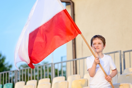 Little boy - Polish football team fan - supporter with Polish flag on the stadiumの写真素材