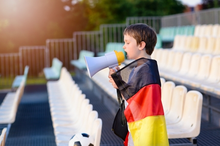 Little boy - Germany national football team fan - screaming through megaphone on the stadiumの写真素材
