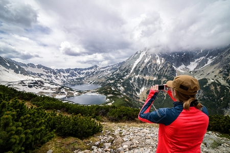 Young woman taking photo of 5 Ponds Valley in Polish Tatra Mountains. Tatra National Parkの写真素材