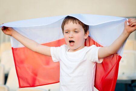 Polish football fan - little boy with Polish flag supporting national teamの写真素材