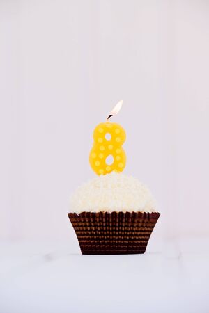 Birthday's cake - muffin with a candle in the shape of a figure 8. Happy birthday !の写真素材